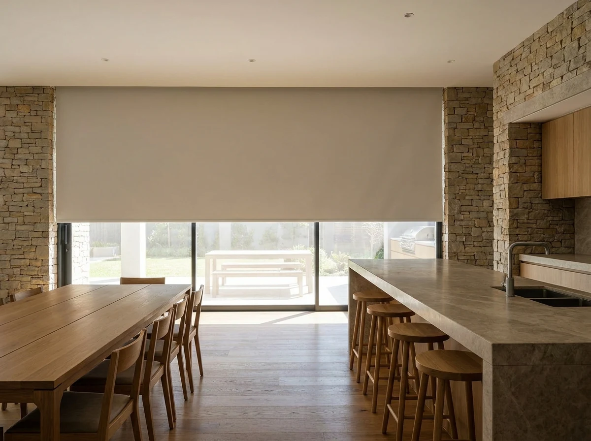 Blockout roller blind lowered over a wide window in an open-plan Beaulieu kitchen and dining area